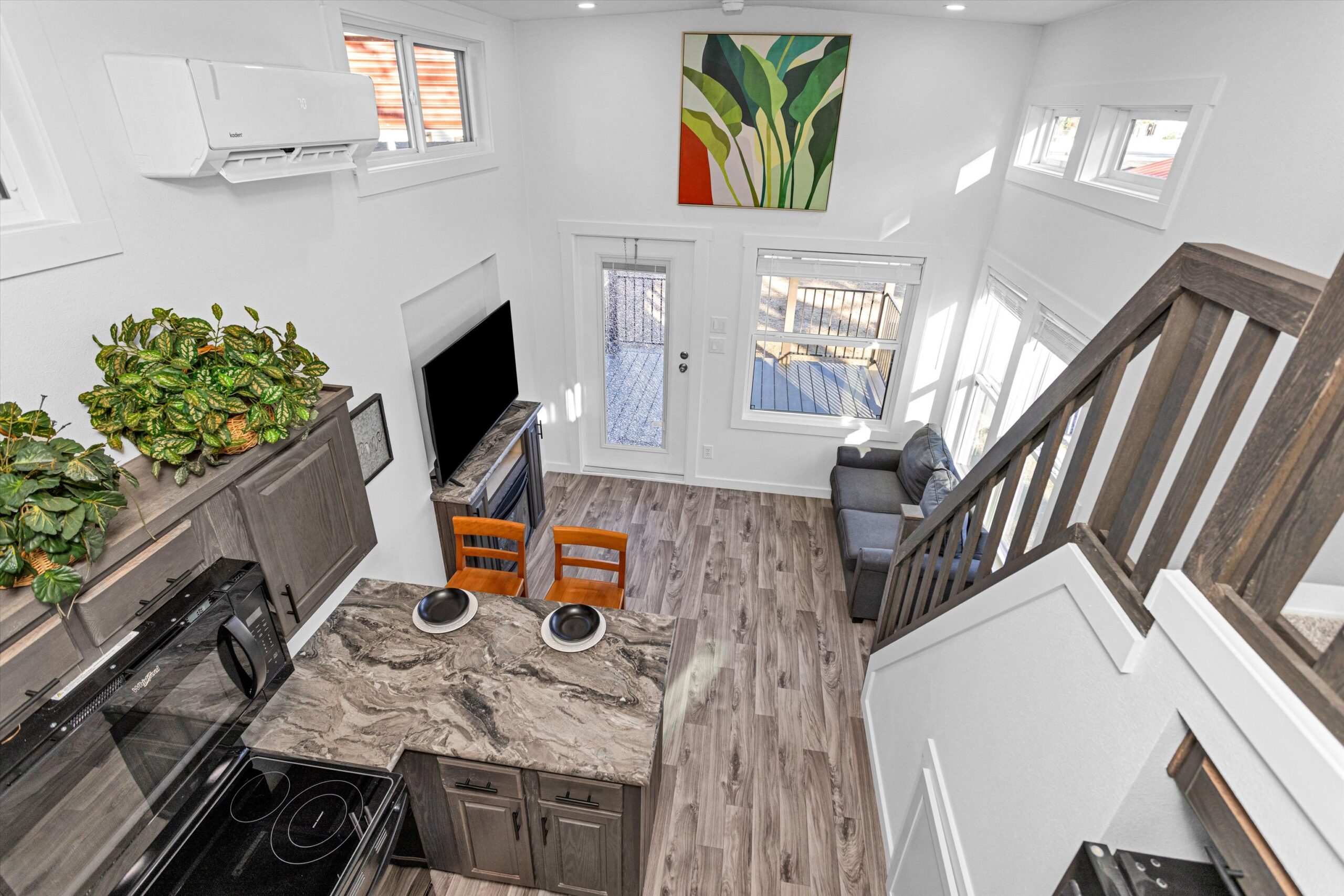 Loft stairway inside Barn Owl tiny home by Platinum leading down to open living area